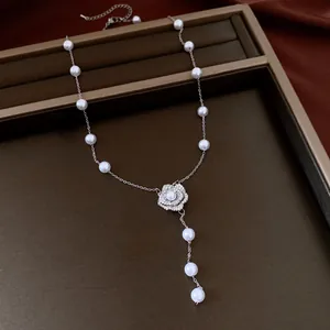 Detailed macro view of elegant white pearl necklace with sparkling zircon flower pendant