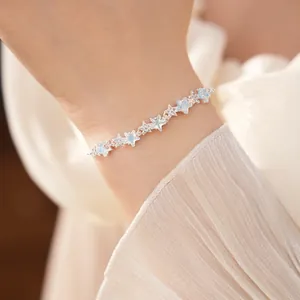 Detailed view of a delicate silver star bracelet with zircons on a woman's wrist