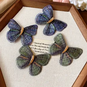 Elegant embroidered butterfly hair clips in teal and purple for women's hair accessories.