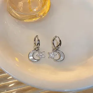 Vue détaillée de boucles d'oreilles en argent avec étoile en zircon et lune en nacre