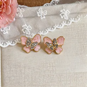 Detailed view of pink butterfly earrings with rhinestones and gold-tone finish.