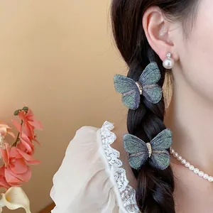 Elegant embroidered butterfly hair clips in blue-green gradient on braided hair