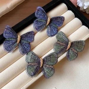 Exquisite embroidered butterfly hair clips in purple and green on jewelry tray