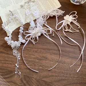 Detail view of pearl beaded flower tassel necklace and white lace choker on wood surface.