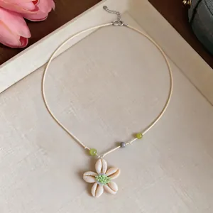 Dettaglio di una dolce collana estiva con fiori in conchiglia di resina per donna gioielli