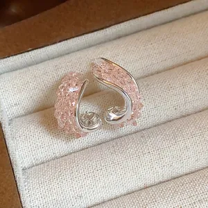 Close-up of twisted irregular silver stud earrings with pink textured glass fragments