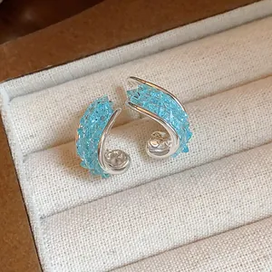 Exquisite twisted stud earrings with sparkling blue crushed glass in silver finish