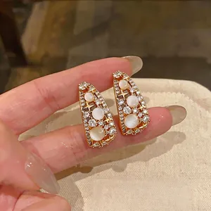 Eleganti orecchini retrò dorati traforati con stelle di zircone e pietre simili all'opale