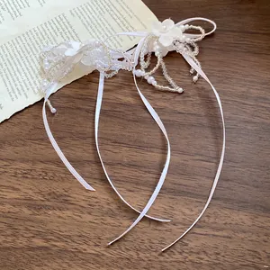 Close-up of elegant white pearl beaded choker with flower details and flowing ribbons