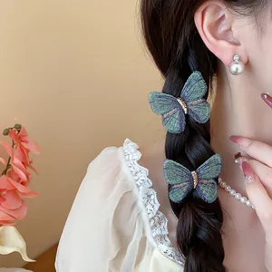 Detailed macro view of elegant embroidered butterfly hair clips on a braided hairstyle.