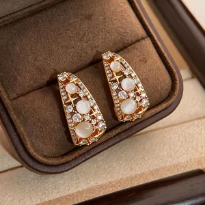 Orecchini vintage placcati oro con motivo a stella, design traforato ed eleganti pietre bianche.