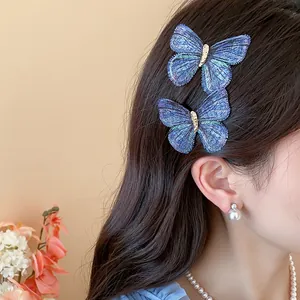 Close-up detail view of blue embroidered butterfly hair clips worn on side hair.
