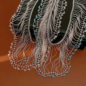 Detailed view of an elegant silver fringe necklace with blue glass beads on a black gift box