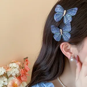 Detailed view of blue embroidered butterfly hair clips styled elegantly on dark hair