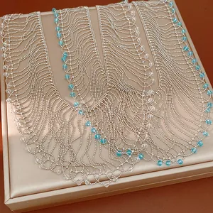 Close-up detail of an elegant silver beaded fringe necklace with blue glass crystal accents