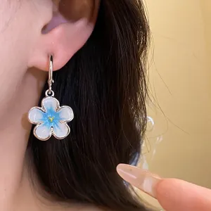 Eleganti orecchini in argento a forma di C con ciondolo a fiore in smalto blu e bianco.
