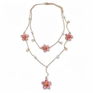 Double-layered gold necklace with pink enamel flower pendants and faux pearls