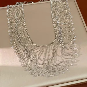 Close-up of elegant silver fringe statement necklace with clear glass beads detailing