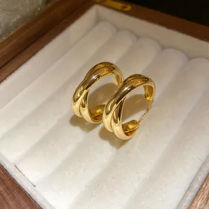 Detalle del diseño trenzado de los pendientes de aro bañados en oro de 18K.