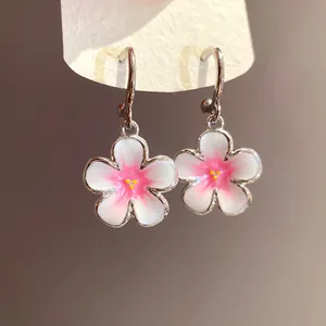 Vista dettagliata di eleganti orecchini a fiore rosa e bianco con finiture argentate