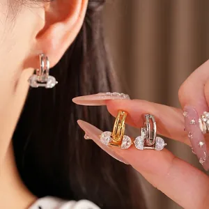 Elegant 18K gold plated oval hollow hoop earrings with zircons shown on ear and hand