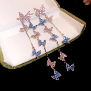 Macro view of sparkling crystal butterfly tassel earrings with blue and pink zircons