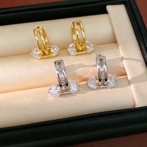 Detail of gold and silver zircon hoop earrings with oval stones in jewelry box