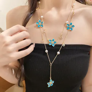 Elegant Y-shaped layered necklace with blue enamel flowers and white faux pearls.