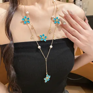 Close-up of layered blue enamel flower necklace with faux pearls and Y-shaped chain