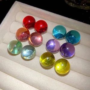 Colorful minimalist resin sphere stud earrings with silver needles set in display tray.