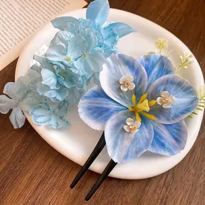 Beautiful blue lily silk floral hair clip accessory displayed on white ceramic plate