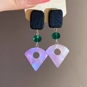 Macro detail of square wood and iridescent resin fan-shaped drop earrings for women