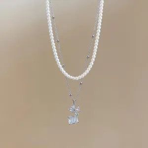 Primer plano del collar de perlas de doble capa con colgante de caja de regalo de cristal