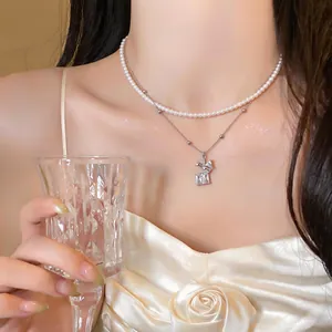 Vista detallada de un collar de perlas en capas con un colgante de flor de diamantes en modelo.