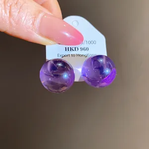 Close-up of purple translucent round resin stud earrings with a dreamy glow.