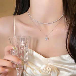 Primer plano de un collar de dos capas con un colgante de diamante cuadrado brillante