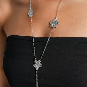 Detail view of a silver-toned metal flower necklace featuring delicate tassel chain design