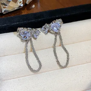 Detailansicht eleganter Herz-Zirkon-Ohrclips mit filigranen hängenden Metallketten