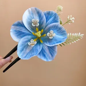 Close-up view of a blue lily flower hair clip with delicate petals and spring aesthetic