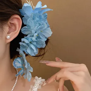 Detail of elegant blue artificial lily floral hair clip worn on model side profile