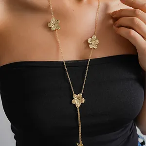 Detailed macro view showing the vintage gold metal flower and tassel texture of the necklace