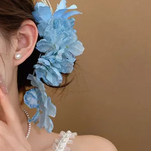 Elegant light blue lily fabric flower hair clip worn by a model for fairy style