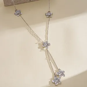 Detailed close-up view of a silver floral tassel Y-necklace with textured flower charms.