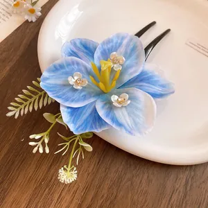 Macro detail of a spring-themed blue lily hair clip with sparkling crystal flower centers