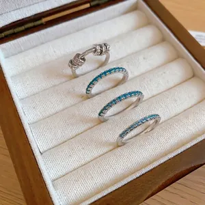 Stackable mint green zircon eternity rings and sliding bead ring in a jewelry box