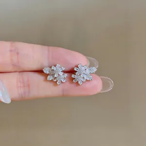Primo piano di orecchini a lobo a fiore in zircone con dettagli luccicanti