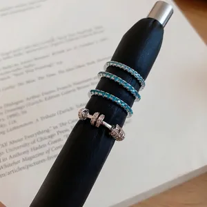 Korean style zircon mint green row drill ring set elegantly displayed on a black pen