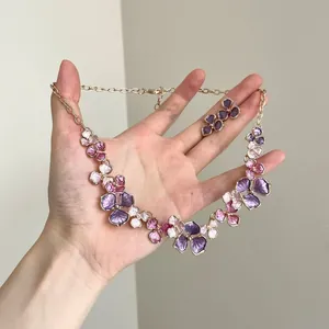 Close-up detail of a spray-painted purple flower pendant necklace and earring jewelry set
