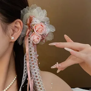 Detailed close-up view of a pink rose lace hair clip with elegant ribbons on a model's hair.