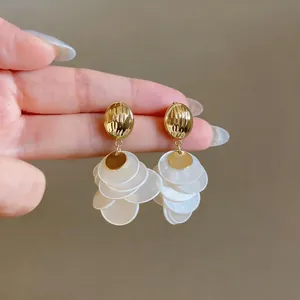 Macro view of vintage French style gold stud earrings with layered shell petals
